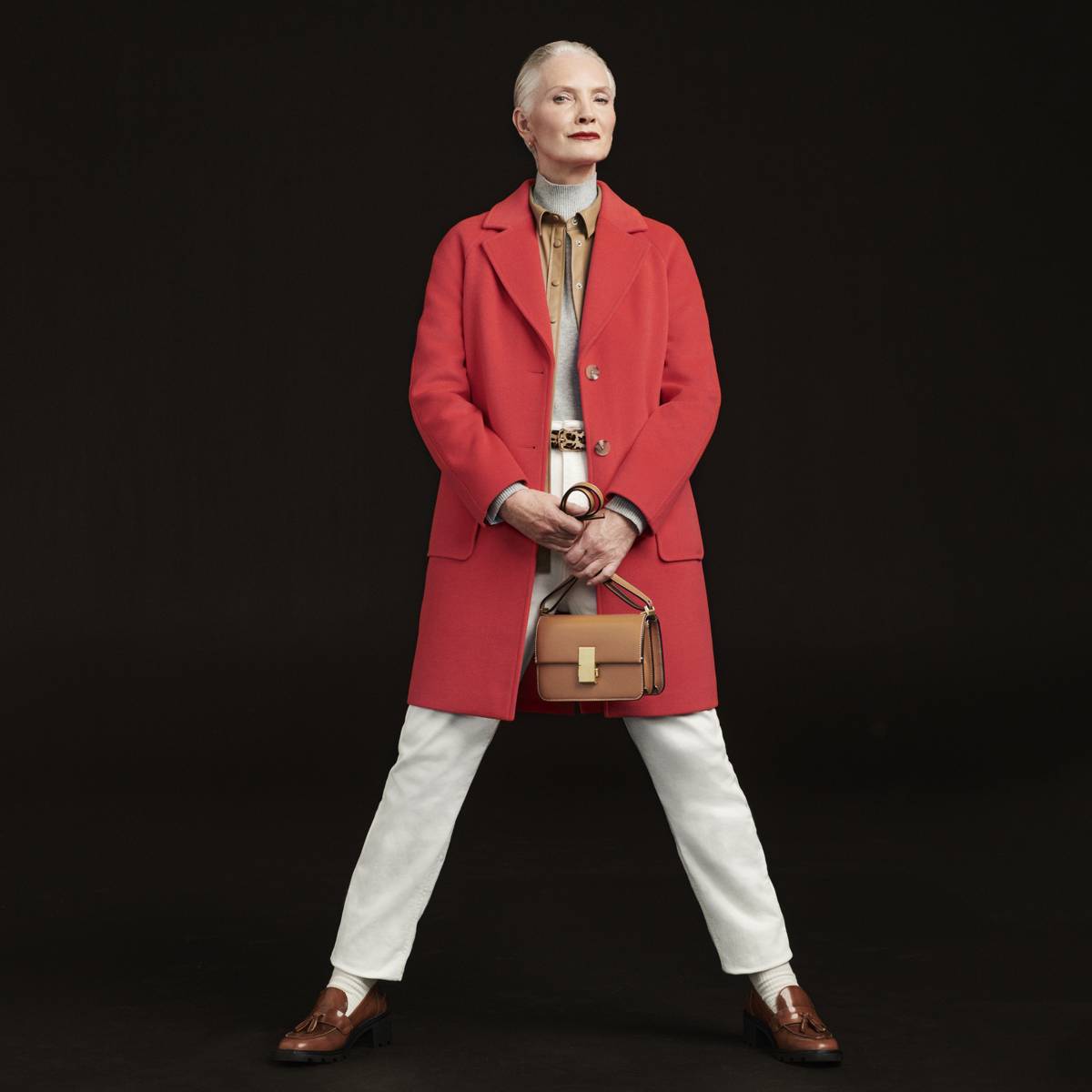 Woman wearing a red coat and white trousers. Shop new in